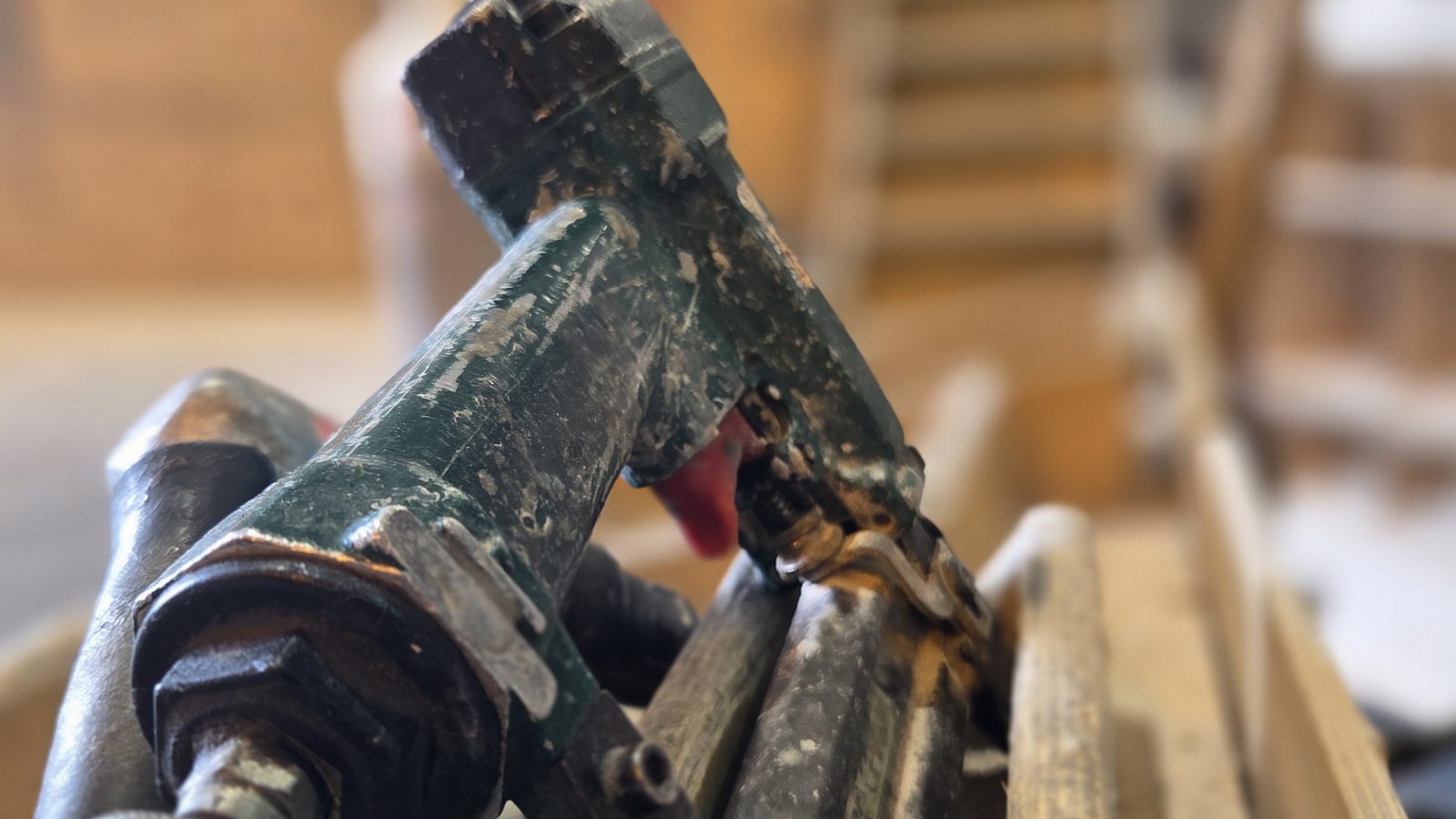 Pneumatic staple gun used for hand assembly of speaker cabinets in the workshop.