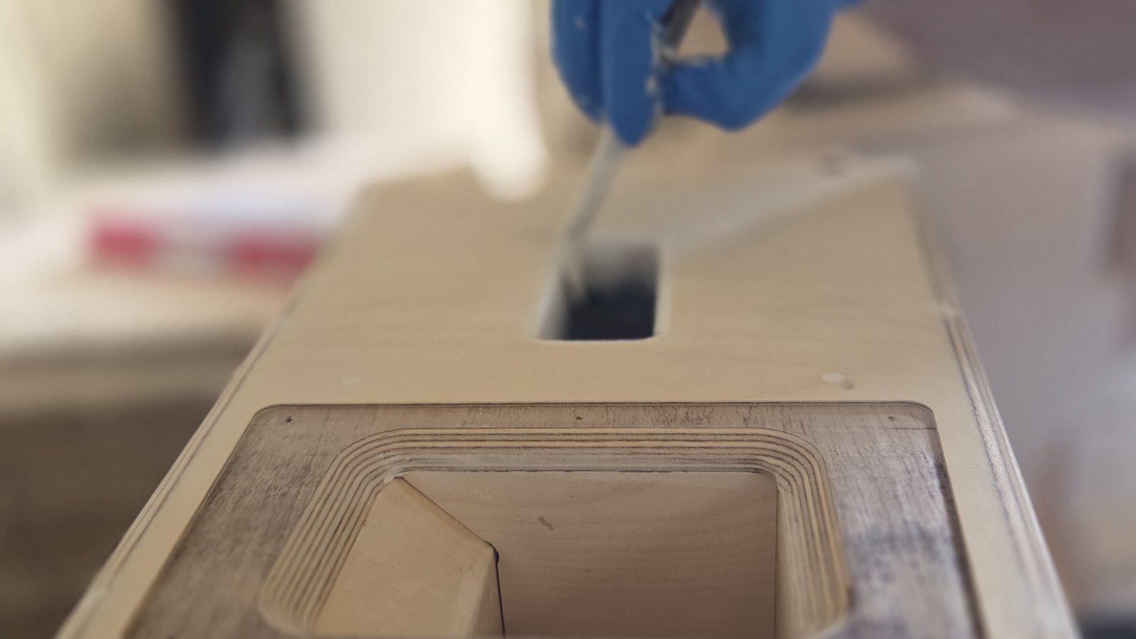 Hand sealing a precision horn cutout for airtight speaker cabinet performance.