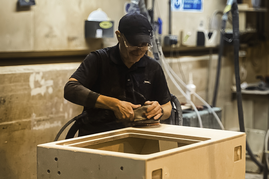 Hand-sanding detail during cabinet assembly at the Sarivale workshop.